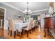 Traditional dining room features a chandelier, hardwood floors, and a long table with seating for ten at 1074 Glenloch Rd, Roopville, GA 30170