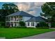 Charming two-story white brick home with black shutters, balcony and well-manicured lawn at 1074 Glenloch Rd, Roopville, GA 30170
