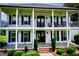 Upclose view of the home's front porch and manicured lawn with white columns and brick stairs at 1074 Glenloch Rd, Roopville, GA 30170