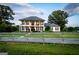 Beautiful white two-story home behind a wooden fence, surrounded by a lush green lawn and mature trees at 1074 Glenloch Rd, Roopville, GA 30170