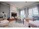 Sunlit living room showcasing hardwood floors, a fireplace, seating and windows at 1074 Glenloch Rd, Roopville, GA 30170