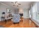 Bright living room featuring hardwood floors, fireplace, ceiling fan and natural light at 1074 Glenloch Rd, Roopville, GA 30170