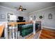 Cozy loft living room area features a plush green sofa, wood railing, and staircase at 1074 Glenloch Rd, Roopville, GA 30170
