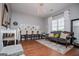Bright living room featuring wood floors, chandelier, seating, and large window at 1074 Glenloch Rd, Roopville, GA 30170