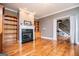 Cozy living room with a fireplace, hardwood floors, and built-in shelving at 1074 Glenloch Rd, Roopville, GA 30170