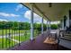 Large covered porch with seating overlooking green fields at 1074 Glenloch Rd, Roopville, GA 30170