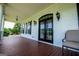 Inviting outdoor porch featuring dark stained wood floors and stylish lighting at 1074 Glenloch Rd, Roopville, GA 30170