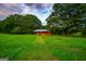 Idyllic shed nestled in a serene landscape with mature trees and lush green grass at 1074 Glenloch Rd, Roopville, GA 30170