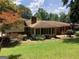 Large, grassy backyard with a brick patio and mature trees surrounding the property at 3746 Gladney Dr, Atlanta, GA 30341