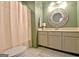Bathroom with a white vanity, decorative mirror, light fixture and green walls at 504 Ridgelake Dr, Peachtree City, GA 30269