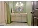 Bathroom with a white vanity, decorative mirror, light fixture and green walls at 504 Ridgelake Dr, Peachtree City, GA 30269
