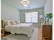 Bedroom with a wooden bed frame, neutral bedding, light fixture, and wood floors at 504 Ridgelake Dr, Peachtree City, GA 30269