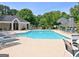 Community pool featuring a pool house, trees, lounge chairs, and landscaping at 504 Ridgelake Dr, Peachtree City, GA 30269