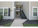 Condo building with siding, black shutters, mulch beds, concrete walkway, and staircase to upper level at 504 Ridgelake Dr, Peachtree City, GA 30269