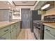 Well-equipped kitchen featuring modern appliances, neutral countertops and tiled floors at 504 Ridgelake Dr, Peachtree City, GA 30269