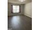 Open living room featuring gray laminate floors, neutral paint, and natural light at 645 Stadler Pointe, Mcdonough, GA 30253