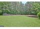 Expansive backyard featuring a large grass area, mature trees, an in-ground pool and a storage shed at 85 Holly Springs Rd, Sharpsburg, GA 30277
