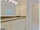 Bathroom with white vanity, solid countertop, large mirror, and half-moon window letting in natural light at 85 Holly Springs Rd, Sharpsburg, GA 30277