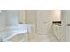 This bathroom boasts a soaking tub, a vanity with countertop, and bright white tiles on the floor at 85 Holly Springs Rd, Sharpsburg, GA 30277