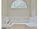 Soaking tub is complete with chrome fixtures, a bright window, and easy access for relaxation at 85 Holly Springs Rd, Sharpsburg, GA 30277