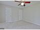Spacious bedroom featuring neutral carpet and walls, a ceiling fan, and two doors for easy access at 85 Holly Springs Rd, Sharpsburg, GA 30277