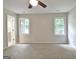 Bedroom with neutral paint, updated ceiling fan, carpet and windows at 85 Holly Springs Rd, Sharpsburg, GA 30277