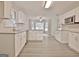 Spacious kitchen features white cabinets, granite counters, stainless appliances and hardwood style floors at 85 Holly Springs Rd, Sharpsburg, GA 30277