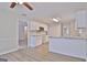 Open kitchen features white cabinets, stainless steel microwave, granite counters and hardwood style floors at 85 Holly Springs Rd, Sharpsburg, GA 30277