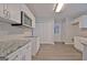 Kitchen features white cabinets, stainless steel microwave, granite counters and hardwood style floors at 85 Holly Springs Rd, Sharpsburg, GA 30277