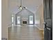 Living room with stone fireplace, high ceilings, ceiling fan, wood flooring, and backyard access at 85 Holly Springs Rd, Sharpsburg, GA 30277
