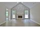 Spacious living room with fireplace and hardwood floors, next to a room with a kitchen and backyard view at 85 Holly Springs Rd, Sharpsburg, GA 30277