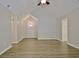 Hardwood-floored living room with cathedral ceiling and a doorway leading to a well lit exterior door at 85 Holly Springs Rd, Sharpsburg, GA 30277