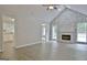 Open-concept living room with stone fireplace and wood flooring, offering an open view of the kitchen at 85 Holly Springs Rd, Sharpsburg, GA 30277