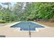 An in-ground swimming pool with a concrete patio and surrounded by mature trees at 85 Holly Springs Rd, Sharpsburg, GA 30277