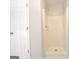 Standing shower has bright, clean walls and a door leading to the rest of the bathroom at 85 Holly Springs Rd, Sharpsburg, GA 30277