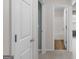 Neutral hallway connecting to a bathroom with dual sinks and soaking tub at 120 Bramble Bush Trl, Covington, GA 30014