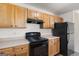 Functional kitchen with wood cabinets, black appliances, and light countertops at 120 Bramble Bush Trl, Covington, GA 30014