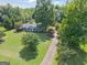 An aerial view showcases the long driveway, mature trees, and landscaped front yard at 1120 Rawlings Dr, Rutledge, GA 30663