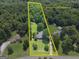 Aerial view highlighting approximate property lines, revealing a home amidst lush greenery and trees at 1120 Rawlings Dr, Rutledge, GA 30663