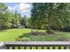 Expansive, green backyard with mature trees, a shed and a small deck at 1120 Rawlings Dr, Rutledge, GA 30663