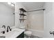 Bathroom featuring shower-tub combo with decor shelving, updated vanity, toilet, and fixtures at 1120 Rawlings Dr, Rutledge, GA 30663