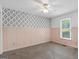 Bedroom with neutral carpet, wainscoting, patterned accent wall, and a ceiling fan at 1120 Rawlings Dr, Rutledge, GA 30663