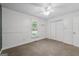 Bright bedroom with neutral carpet, wainscoting, closet, ceiling fan and window view at 1120 Rawlings Dr, Rutledge, GA 30663