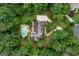 Aerial view showcasing a home with a pool, driveway, and surrounding greenery at 140 Silvermere, Fayetteville, GA 30215