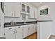 Stylish bar area features white cabinets, black countertops, a sink, and decorative accents at 140 Silvermere, Fayetteville, GA 30215