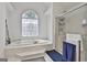 Bright bathroom with a large tub under a decorative window and a separate shower at 140 Silvermere, Fayetteville, GA 30215