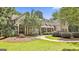 Inviting home exterior with manicured lawn, mature trees, a covered porch, and a welcoming walkway at 140 Silvermere, Fayetteville, GA 30215