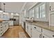 Spacious kitchen boasts white cabinets, granite countertops, stainless steel appliances, and ample natural light at 140 Silvermere, Fayetteville, GA 30215
