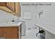 Functional laundry room featuring white washer and dryer, storage cabinets, and folding table at 140 Silvermere, Fayetteville, GA 30215