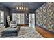 Stylish living room features hardwood floors, unique wallpaper, and a modern light fixture, creating a distinctive space at 140 Silvermere, Fayetteville, GA 30215